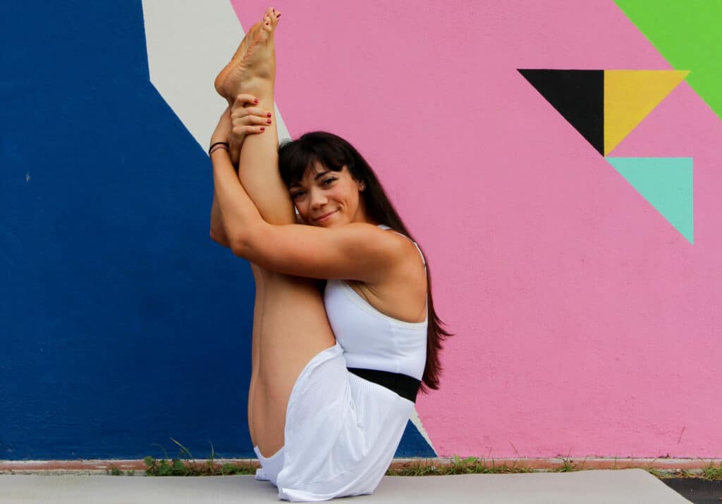 Krista Shirley gracefully demonstrates Urdhva Mukha Paschimottanasana, a seated yoga pose, in her Maitland, Florida studio, exuding tranquility and strength.